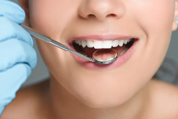 Частковий вид на стоматолога з дзеркалом, що перевіряє жіночі зуби — стокове фото