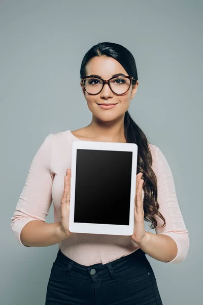 Woman showing digital tablet with blank screen, isolated on grey — Stock Photo