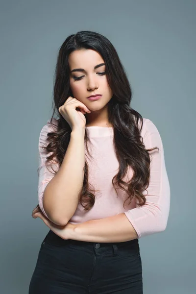 Brunette pensive young woman, isolated on grey — Stock Photo