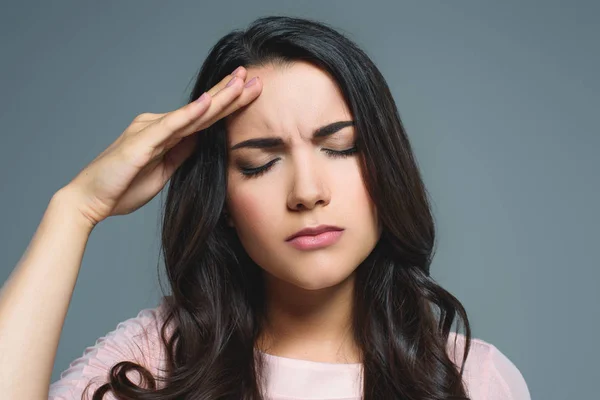 Schöne Frau mit Kopfschmerzen, isoliert auf grau — Stockfoto