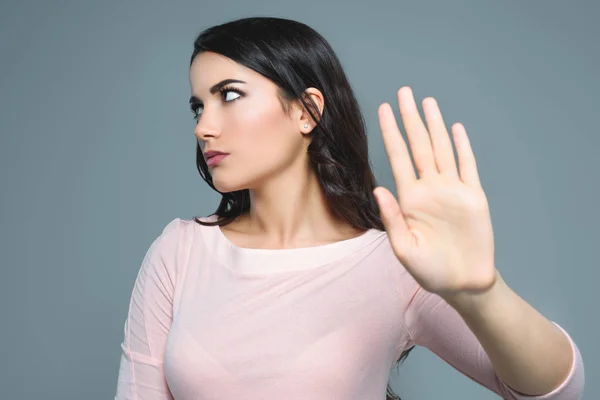 Beautiful girl with bad mood gesturing stop symbol, isolated on grey — Stock Photo