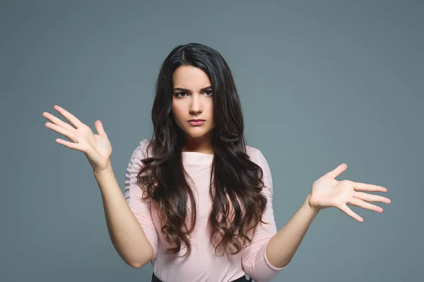 Hermosa chica confundida con gesto de encogimiento, aislado en gris - foto de stock