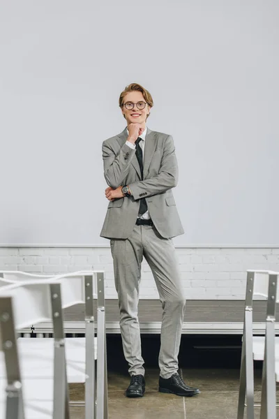 Pensive smiling businessman resting chin on hand in hub — Stock Photo