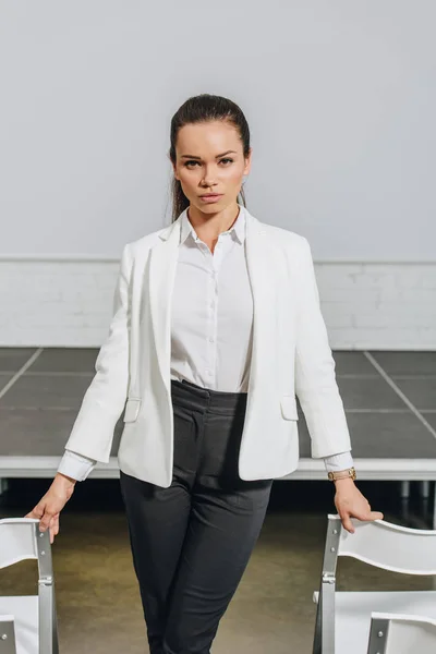 Attractive serious businesswoman looking at camera in hub — Stock Photo