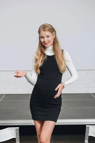Pregnant businesswoman gesturing and looking at camera in hub — Stock Photo