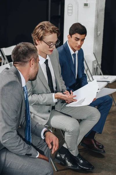 Hommes d'affaires assis sur des chaises pendant la formation et parler de documents en hub — Photo de stock