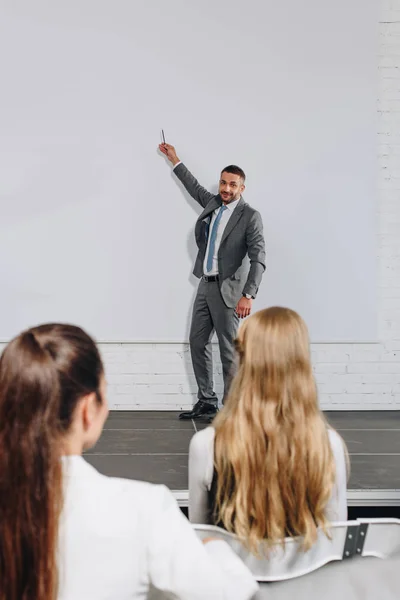 Entrenador de negocios apuntando a bordo durante la formación en el centro - foto de stock