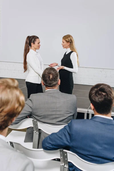 Attractive business coach and businesswoman talking at training in hub — Stock Photo