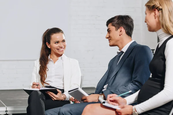 Smiling businesspeople talking during training in hub — Stock Photo