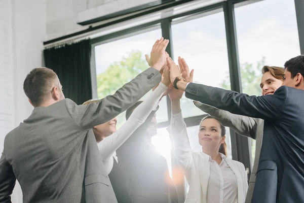 Businesspeople giving high five after training in hub — Stock Photo