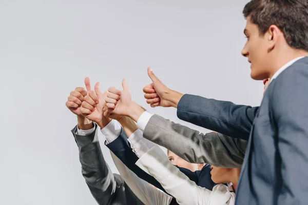 Businesspeople in formal wear showing thumbs up in hub — Stock Photo