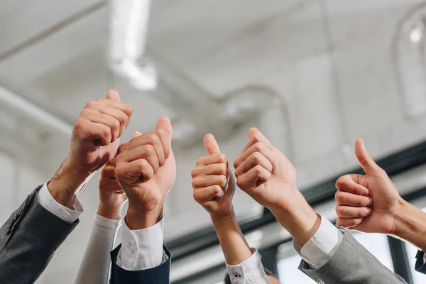 Cropped image of businesspeople showing thumbs up in hub — Stock Photo