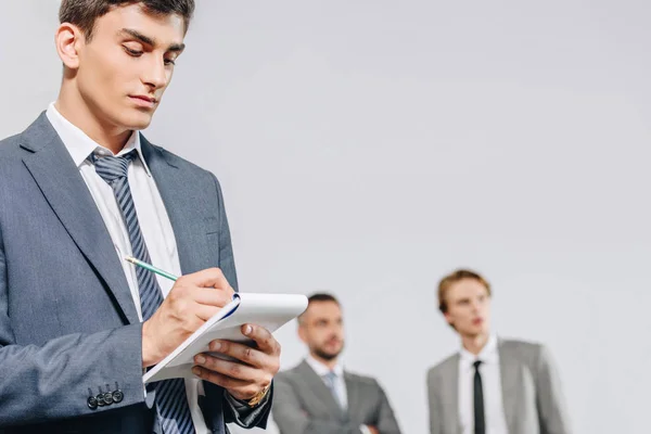 Bel homme d'affaires écrit quelque chose pour ordinateur portable avec crayon dans le moyeu — Photo de stock