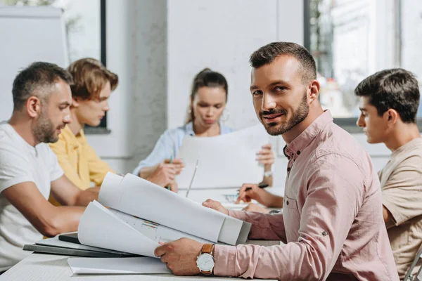 Bell'uomo d'affari che guarda la telecamera durante la riunione in ufficio — Foto stock