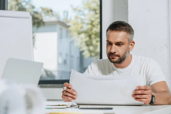 Handsome businessman in shirt reading documents in office — Stock Photo
