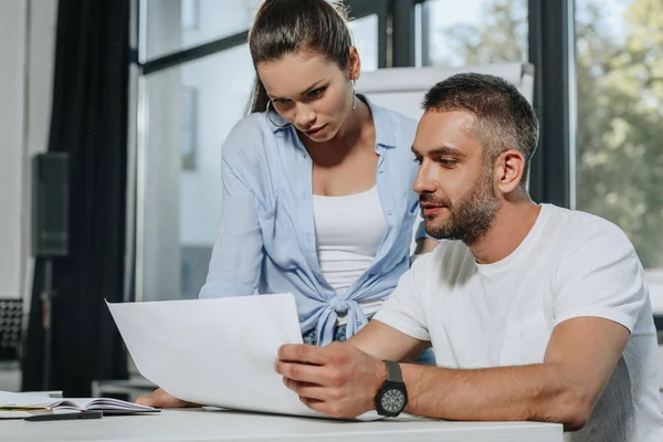 Geschäftsleute schauen sich im Büro Dokumente am Tisch an — Stockfoto