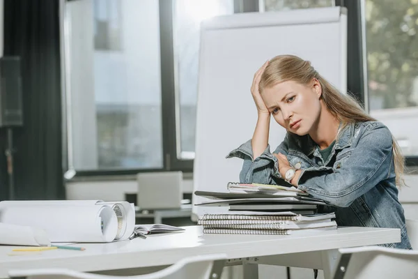 Tired businesswoman sitting at table in office — Stock Photo