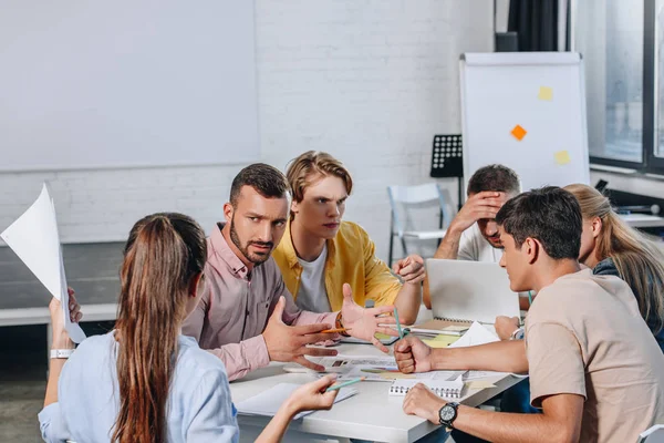 Unzufriedene Geschäftsleute sitzen bei Treffen im Amt mit am Tisch — Stockfoto