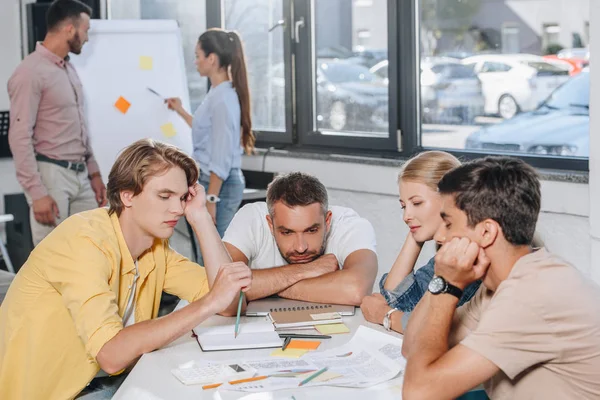 Müde Geschäftsleute lehnen sich bei Treffen im Amt auf den Tisch — Stockfoto