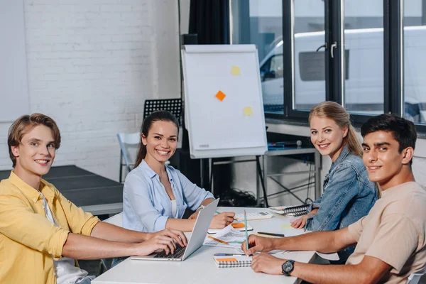 Team sorridente di uomini d'affari che guardano la telecamera durante la riunione in ufficio — Foto stock