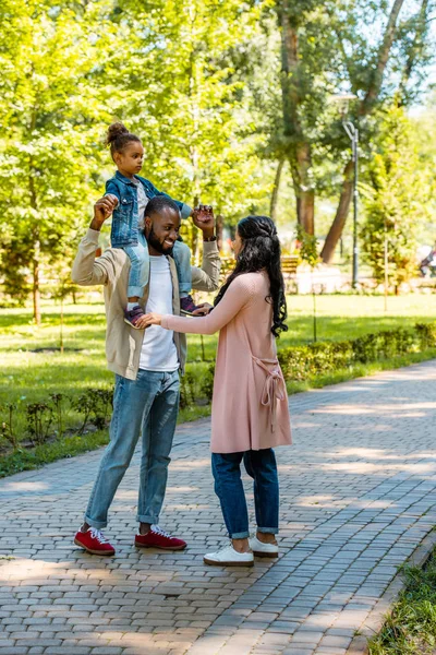 Щасливий афроамериканський батько тримає дочку на плечах в парку — стокове фото