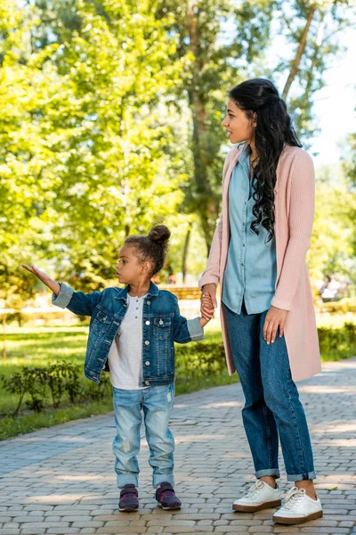 Afrikanisch-amerikanische Tochter zeigt Mutter im Park auf etwas — Stockfoto