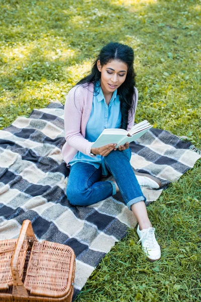 Vista de ángulo alto de la atractiva mujer afroamericana leyendo libro en el parque — Stock Photo