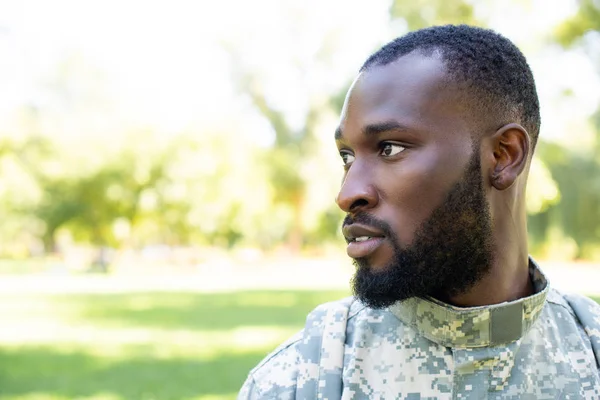 Ritratto di soldato afro-americano in uniforme militare che guarda altrove nel parco — Foto stock