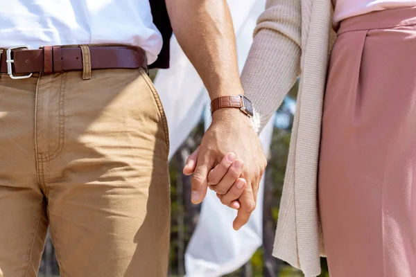 Vista parcial de pareja cogida de la mano - foto de stock