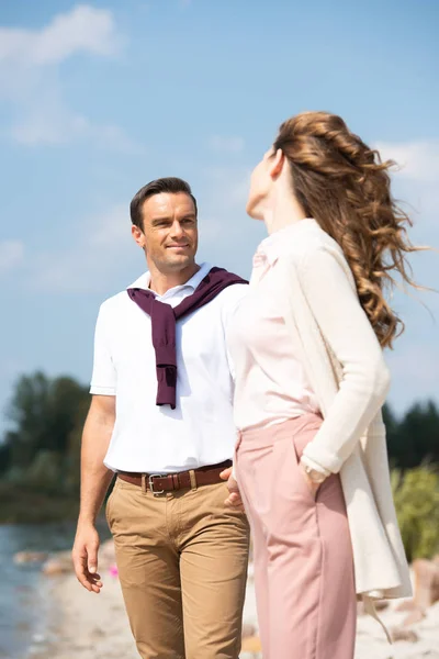 Selective focus of romantic couple looking at each other on sandy beach — Stock Photo