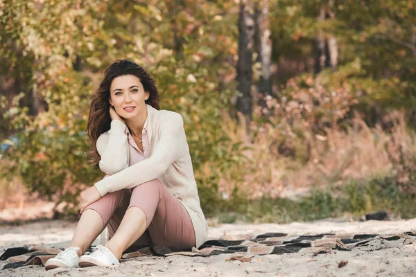 Femme réfléchie reposant sur la couverture seule sur la plage de sable — Photo de stock