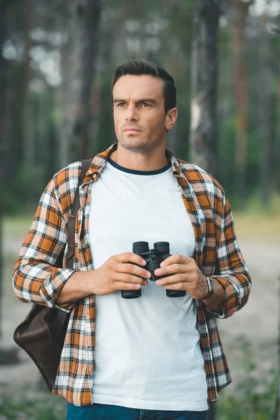 Retrato de turista pensativo com binóculos na floresta — Fotografia de Stock