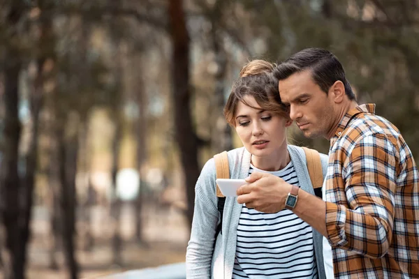 Portrait of tourists looking for destination on smartphone — Stock Photo