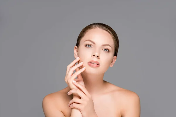 Portrait of beautiful woman with perfect skin looking at camera isolated on grey — Stock Photo