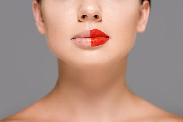 Cropped shot of woman with red lipstick on half of mouth isolated on grey — Stock Photo