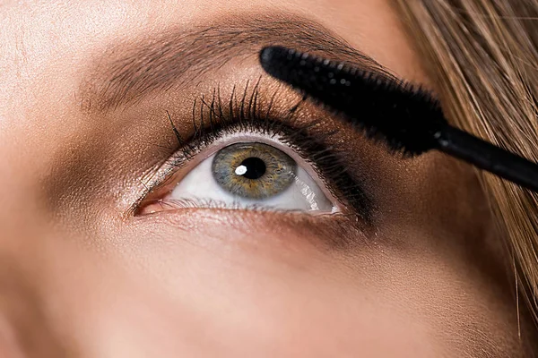 Partial view of attractive woman and mascara brush — Stock Photo