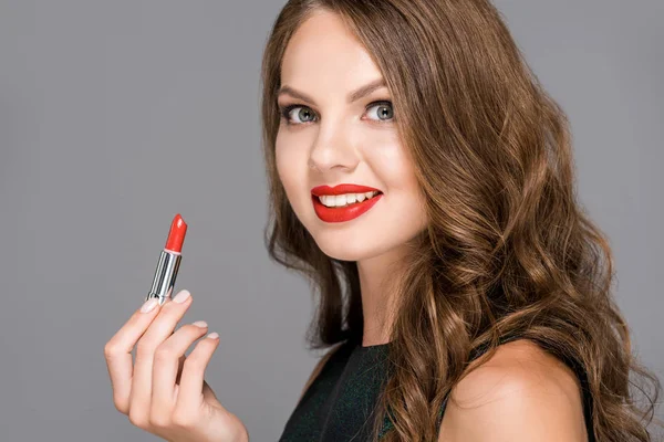 Atractiva mujer sonriente con lápiz labial rojo aislado en gris - foto de stock