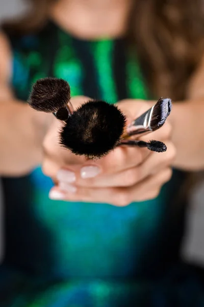 Partial view of woman showing makeup brushes in hands — Stock Photo