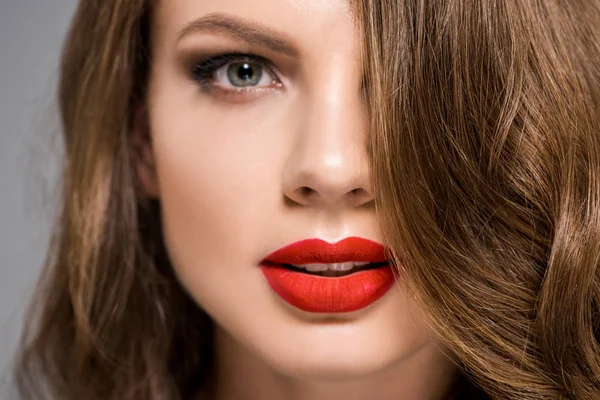 Retrato de mujer joven atractiva con lápiz labial rojo en los labios mirando a la cámara - foto de stock