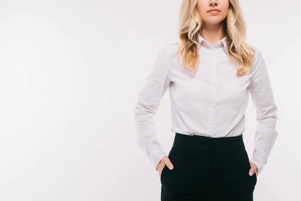 Image recadrée de femme d'affaires debout avec les mains dans des poches isolées sur blanc — Photo de stock