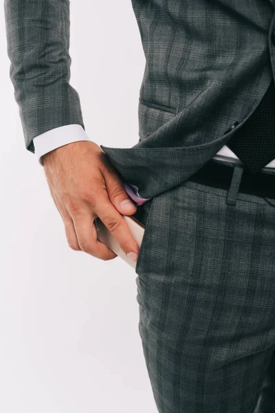 Cropped image of businessman putting smartphone into pocket isolated on white — Stock Photo