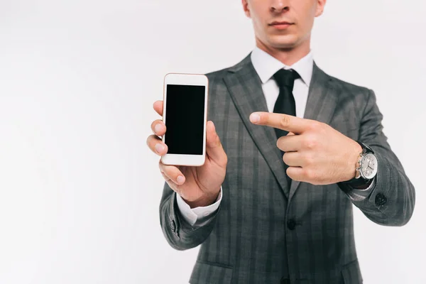 Imagen recortada de hombre de negocios apuntando en el teléfono inteligente con pantalla en blanco aislado en blanco - foto de stock