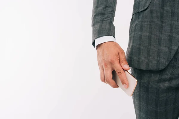 Image recadrée de l'homme d'affaires mettre smartphone dans la poche isolé sur blanc — Photo de stock