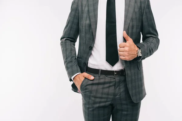 Cropped image of businessman holding jacket and standing with hand in pocket isolated on white — Stock Photo