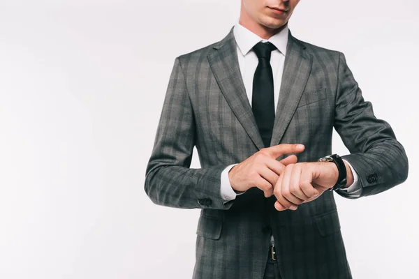 Abgeschnittenes Bild eines Geschäftsmannes, der die Uhrzeit an der Armbanduhr kontrolliert, isoliert auf Weiß — Stockfoto