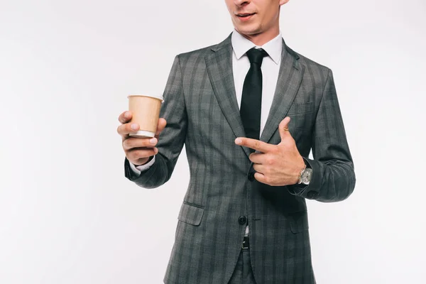 Imagen recortada de hombre de negocios señalando en el café en taza de papel aislado en blanco - foto de stock