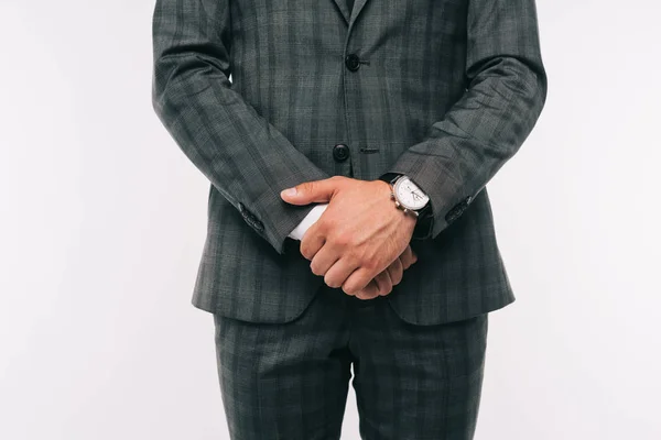 Imagen recortada de hombre de negocios de pie en traje con reloj de pulsera aislado en blanco - foto de stock