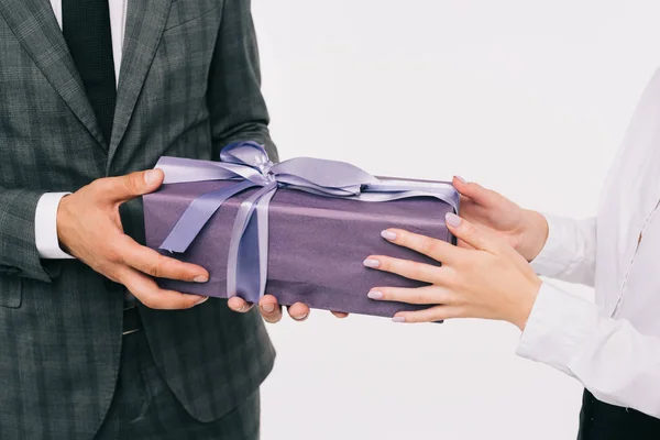 Imagen recortada de la mujer de negocios que presenta regalo a su compañero de trabajo aislado en blanco - foto de stock