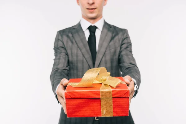 Cropped image of businessman showing gift box isolated on white — Stock Photo
