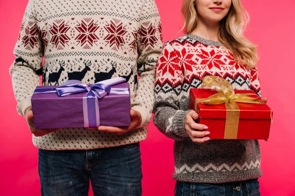 Abgeschnittenes Bild von Paar in Pullovern mit Geschenken isoliert auf rosa — Stockfoto